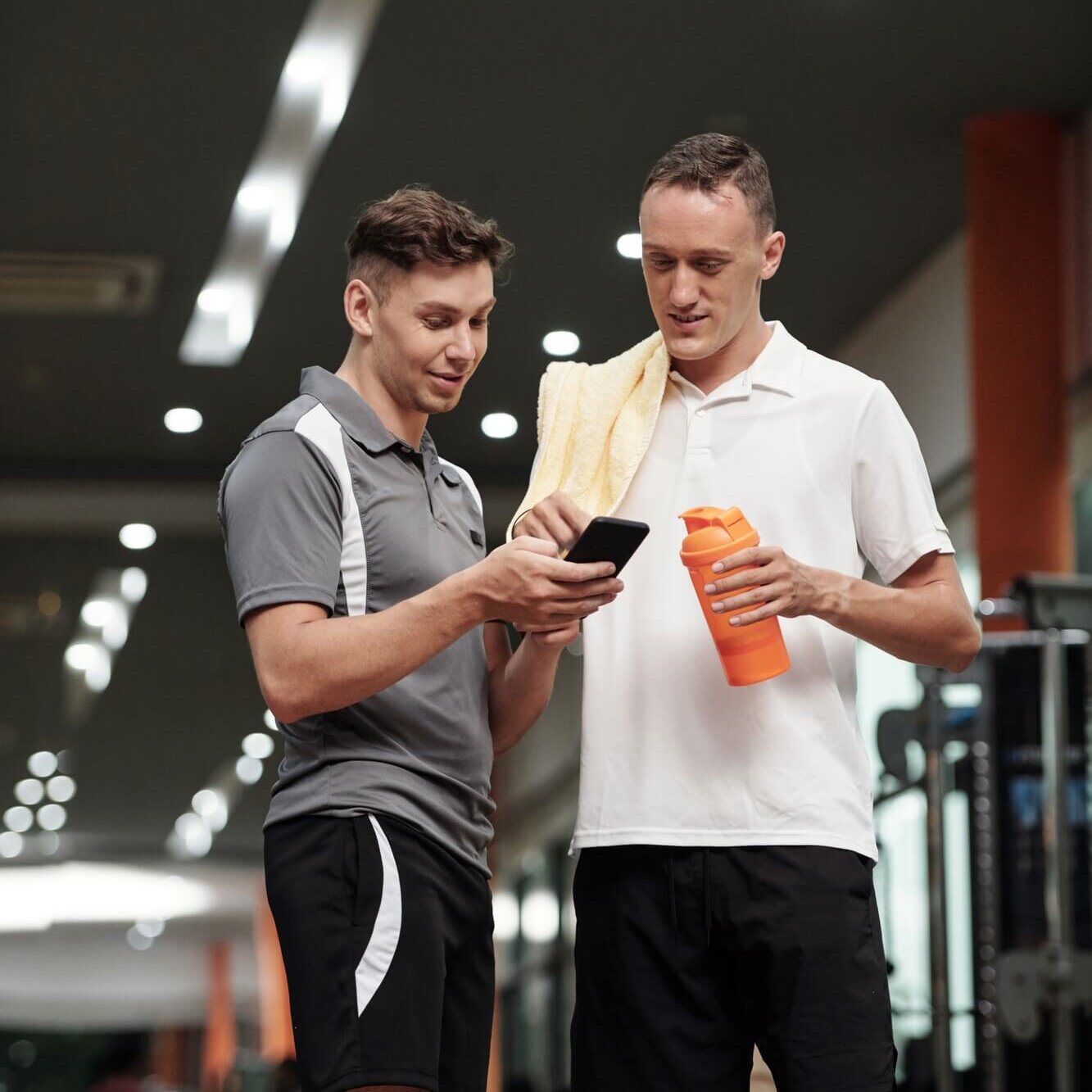 Sportsman Showing Fitness App to Coach
